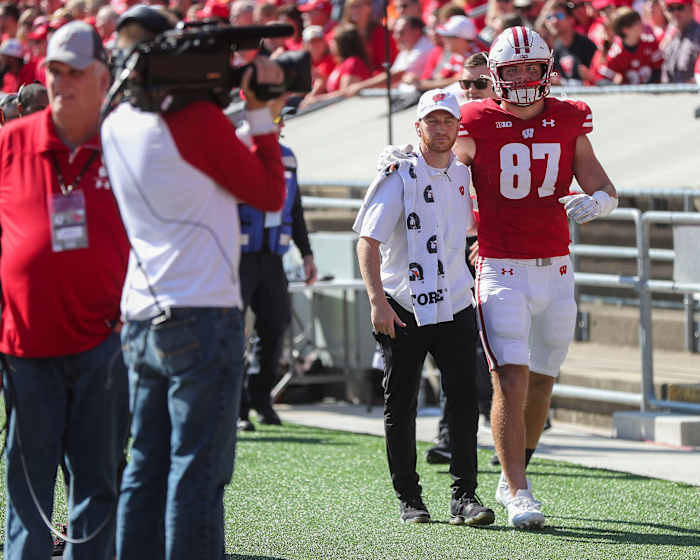 Wisconsin tight end Hayden Rucci being helped to the locker room with an injury.